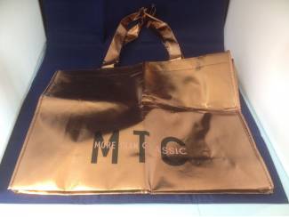 Goudkleurige tas lussen zwarte tekst MTC More than classic
