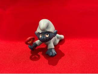 Babysmurf lichtblauw pakje rode rammelaar. Hoogte 3,5 cm  Cijfer